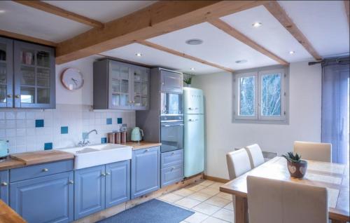 モルジヌにあるBeautiful 3 Bedroom Chalet in Morzineの青いキャビネットと白い冷蔵庫のあるキッチン