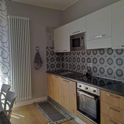 a kitchen with a stove and a microwave at Porta d'Alpi in Latronico
