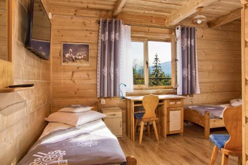 een slaapkamer met een bed en een bureau in een hut bij Dom Wczasowy Na Polanie in Ciche Małe