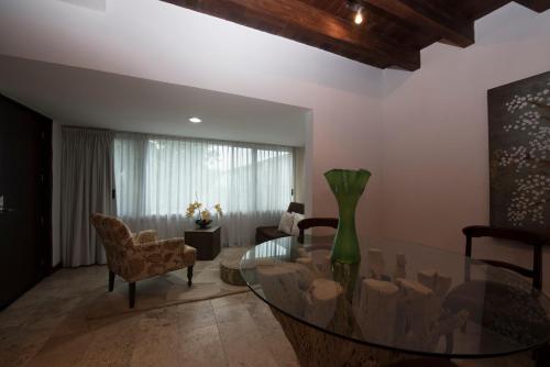 a living room with a glass table and chairs at Colombe Hotel Boutique in Xalapa