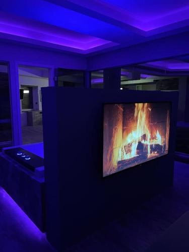 a living room with a tv with a fire on it at Loft mit Whirlpool Sauna Kino nähe Wolfsburg in Helmstedt