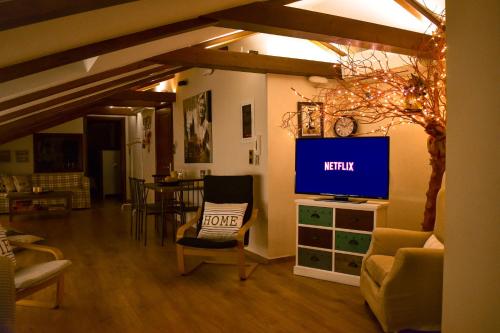 a living room with a tv and a chair at LOFT 38 Ioannina in Ioannina