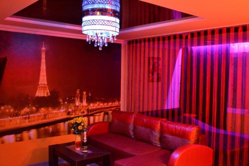 a red couch in a room with a view of the eiffel tower at ApartLux Chernigov in Chernihiv