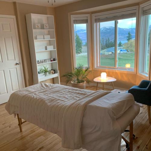 a bedroom with a bed and a large window at Salish B&B and Spa in West Kelowna