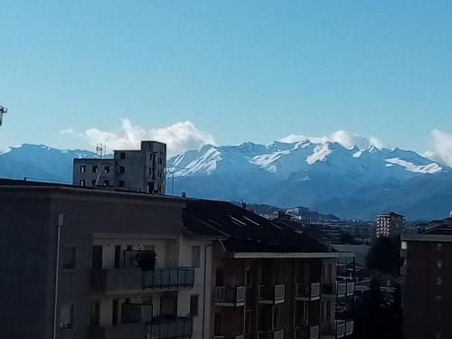 a view of snow capped mountains from a city at BRUNO TURIN APARTMENT Near the METRO in Collegno