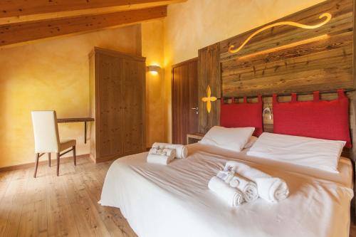 a bedroom with a large bed with towels on it at Residence Samont in Arta Terme