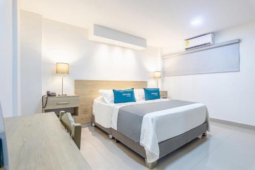 1 dormitorio con 1 cama grande con almohadas azules en Hotel Ancor, en Sincelejo