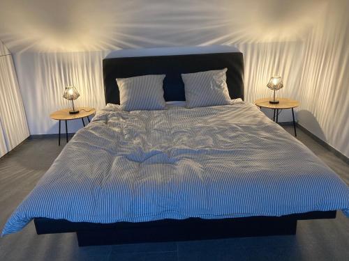 a large bed with two nightstandiatesiatesiatesiatesiatesiatesiatesiatesiates at Maison mystique in Staden
