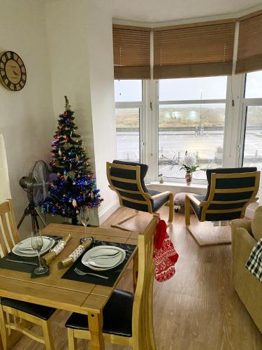 a living room with a christmas tree and a table at Bellaview Apartment Barmouth in Barmouth