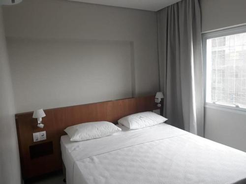 una camera da letto con un letto con due cuscini e una finestra di Salinas Park Resorte Salinopolis a Salinópolis