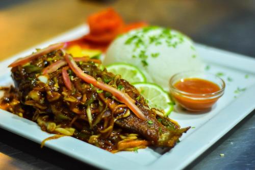 a plate of food with meat and vegetables and sauce at Holiday Inn Dar Es Salaam by IHG in Dar es Salaam