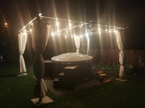 a bath tub in a yard with a string of lights at Noclegi Mazur przysiersk in Przysiersk