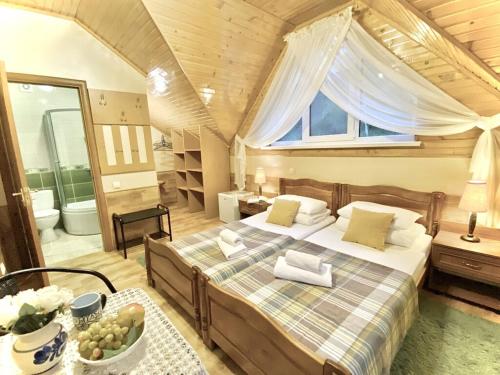1 dormitorio con 1 cama grande y baño en Садиба Оберіг en Skhidnitsa
