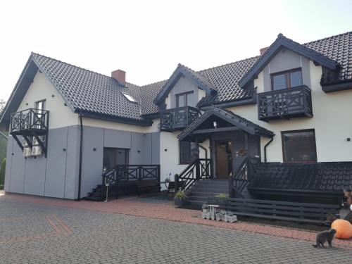 a white house with a black roof at Noclegi Mazur przysiersk in Przysiersk