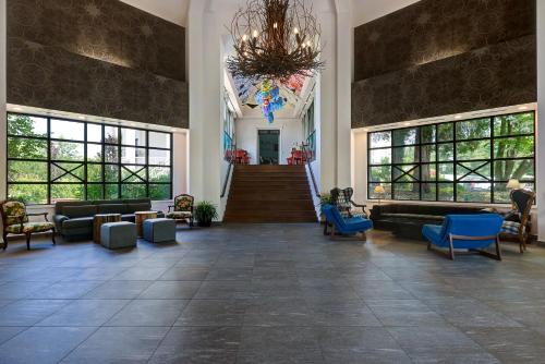 a lobby with a staircase and blue chairs and a chandelier at Tarrytown House Estate in Tarrytown