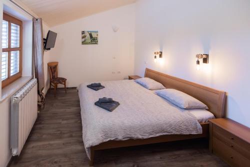 a bedroom with a bed with blue pillows on it at Gordia organic winery in Hrvatini