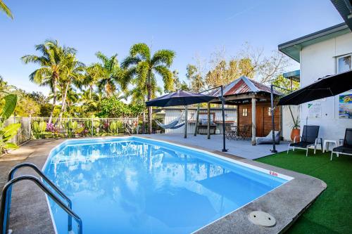 a swimming pool in the backyard of a house at Bush Village Holiday Cabins in Airlie Beach