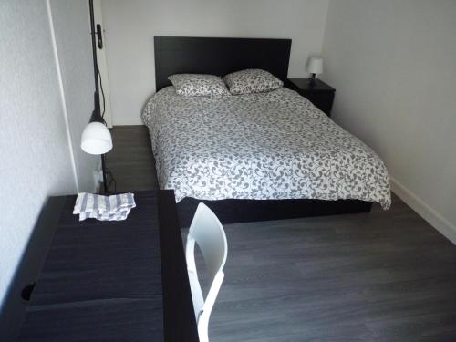 a bedroom with a bed and a table with a chair at Résidence Kerhallet in Brest