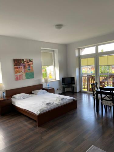 sypialnia z dużym łóżkiem, stołem i krzesłami w obiekcie Apartamenty Przy Porcie 54m2 oraz 31m2 z Tarasem w Węgorzewie