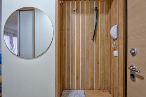 a bathroom with a wooden door with a mirror at Apartman Sanjalica in Zlatibor