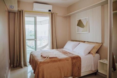 a bedroom with a bed and a large window at Apto espetacular no Pecado entre MAR e LAGOA - WIFI 200MB - Piscina com vista - Garagem - 2 Quartos - TV Smart - Cozinha equipada - Churrasqueira - Ar condicionado in Macaé