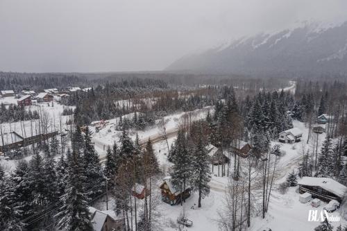 a village covered in snow with trees and mountains at Chair Four Por Favor - Walk Almost Anywhere at Alyeska Resort! in Girdwood