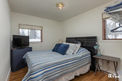 a bedroom with a bed and a flat screen tv at Chair Four Por Favor - Walk Almost Anywhere at Alyeska Resort! in Girdwood
