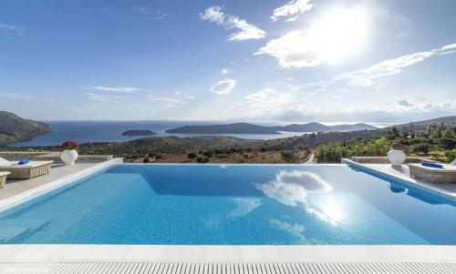 a swimming pool with a view of the ocean at Elounda Villa Kalydon in Elounda