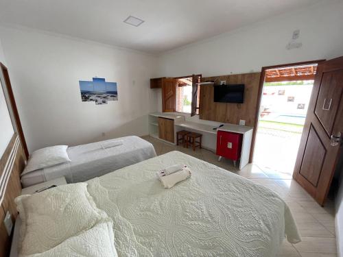 a hotel room with two beds and a television at Pousada Vasto Horizonte in Barreirinhas