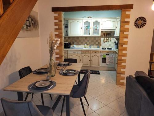 une cuisine avec une table en bois et des chaises ainsi qu'une salle à manger dans l'établissement Appartement cosy style industriel, à Bourges