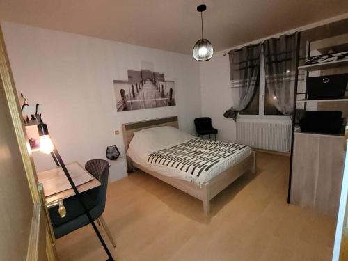 - une chambre avec un lit, une table et un bureau dans l'établissement Appartement cosy style industriel, à Bourges