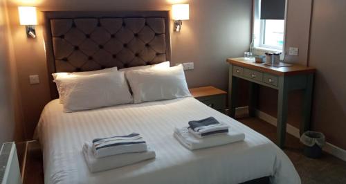 a hotel room with a bed with two towels on it at The Skye Bridge Hotel in Kyle of Lochalsh