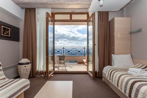 科帕奥尼克Milmari Resort & Spa Suites的有两张床和一个阳台的酒店房间