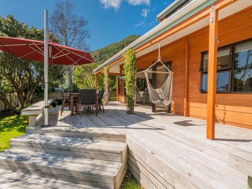 a wooden deck with a hammock on a house at Family Escape - Pauanui Holiday Home in Pauanui