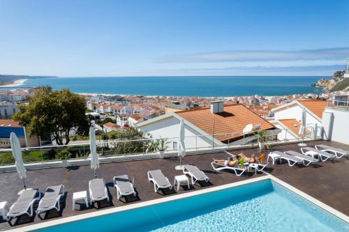 a villa with a swimming pool and a view of the ocean at Veronique Apartment in Nazaré