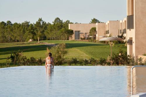 uma mulher parada na água numa piscina em Praia do Canal Nature Retreat em Aljezur