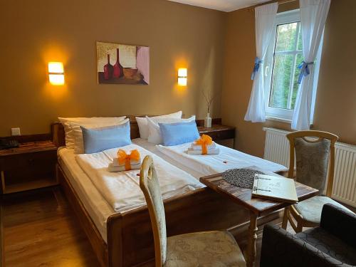 ein Schlafzimmer mit einem großen Bett mit einem Tisch und einem Tisch in der Unterkunft Berghotel Drei Brüder Höhe in Marienberg