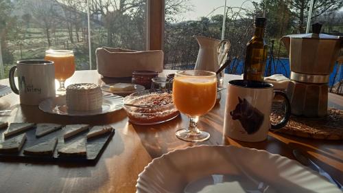 einen Tisch mit Speisen und Getränken und eine Flasche Wein in der Unterkunft Las Lucías, experiencias de ecoturismo in Navatrasierra