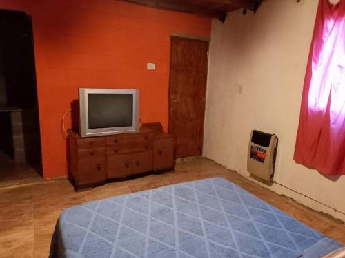 a living room with a tv on a wooden dresser at Casa con Gran Patio in Villa Parque Siquiman