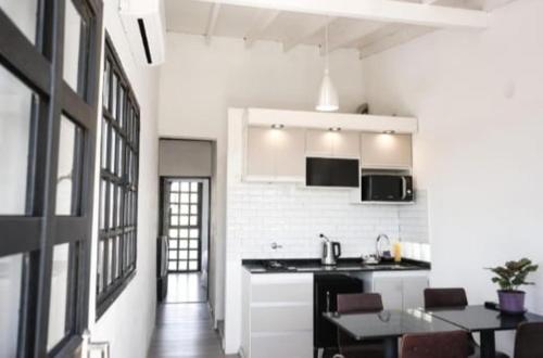 eine Küche mit weißen Wänden und einer schwarzen Arbeitsplatte in der Unterkunft Casa y departamento con pileta Aeropuerto Circunvalacion Kempes Quorum -cambio oficial- in Cordoba