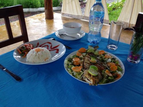 a blue table with two plates of food on it at Mafia Neptune Villa Lodge in Utende
