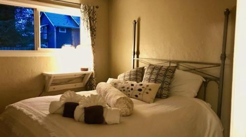 - une chambre avec un lit blanc avec des oreillers et une fenêtre dans l'établissement High Grade - Affordable, Near Mendenhall Glacier, Trails, and Conveniences -DISCOUNT ON TOURS!, à Mendenhaven
