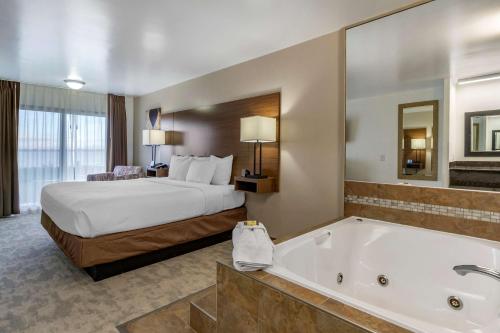 a hotel room with a bed and a bath tub at Best Western PLUS Lake Front Hotel in Moses Lake