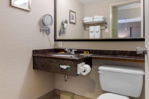 a bathroom with a sink and a mirror and a toilet at Best Western Plus Gatineau-Ottawa Downtown in Gatineau