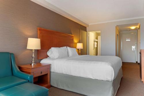 a hotel room with a bed and a blue chair at Best Western Plus Gatineau-Ottawa Downtown in Gatineau