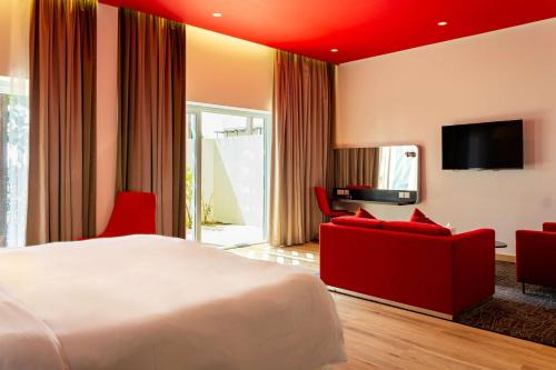 a hotel room with a large bed and red furniture at Park Inn by Radisson Hotel and Residence Duqm in Duqm