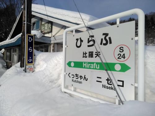 a sign in the snow in front of a house at Ekinoyado Hirafu in Kutchan