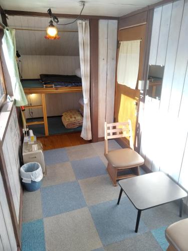 a living room with a chair and a table at Ekinoyado Hirafu in Kutchan