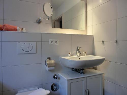 La salle de bains est pourvue d'un lavabo, d'un miroir et de toilettes. dans l'établissement Ferienwohnung W18 2 N, à Graal-Müritz