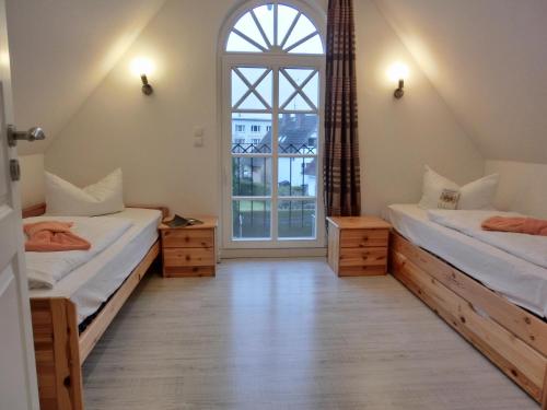 a room with two beds and a large window at Ferienhaus FH17b in Graal-Müritz